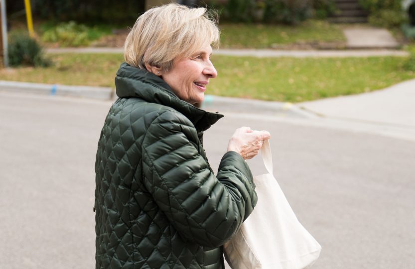 Bate crosses the street, looking toward the area where she has yet to reach out with her striking blue notes. The notes are part of a project Bate embarked on earlier this year.