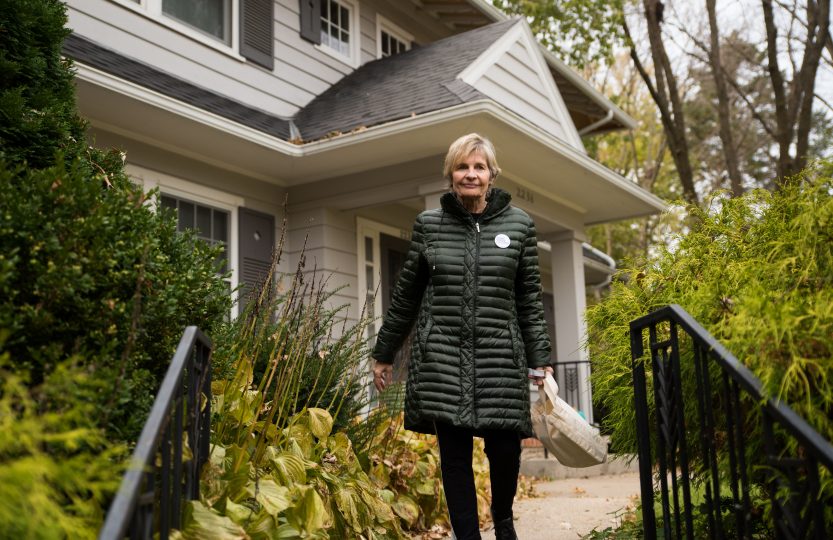 Bate prepares to descend the steps from a neighborhood residence where she just left a note.