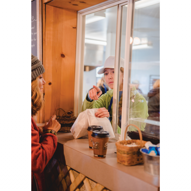 A bakery worker calls out an order for the apple cider donuts that the bakery is well-known for.